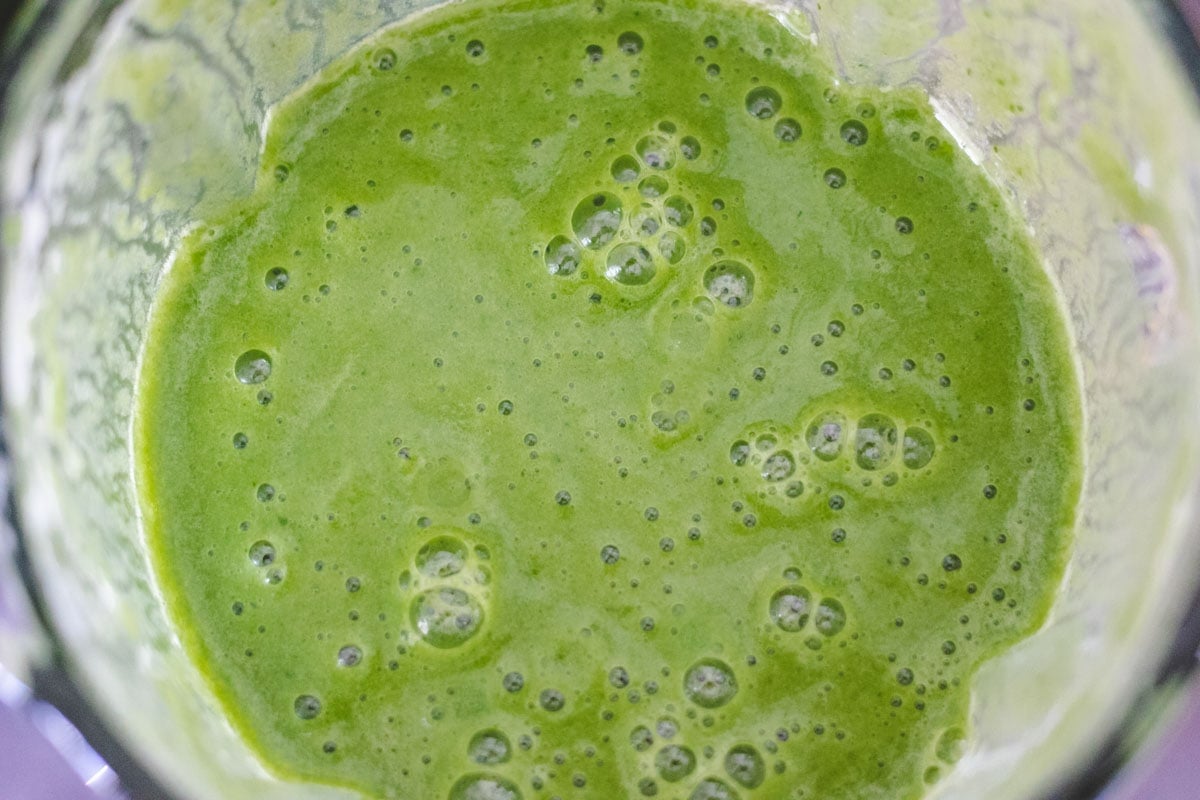 Green smoothie blended in a blender.