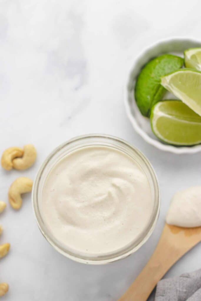 cashew lime crema in a jar with limes