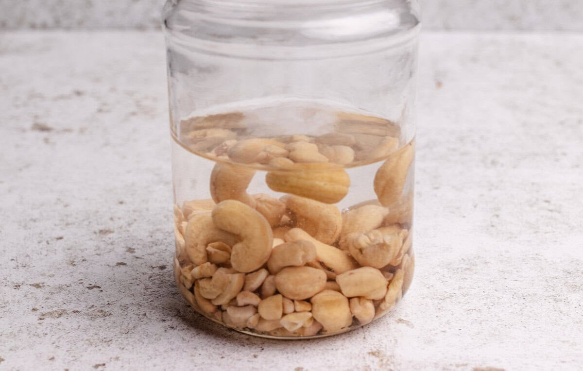 A jar of soaked cashews in water.