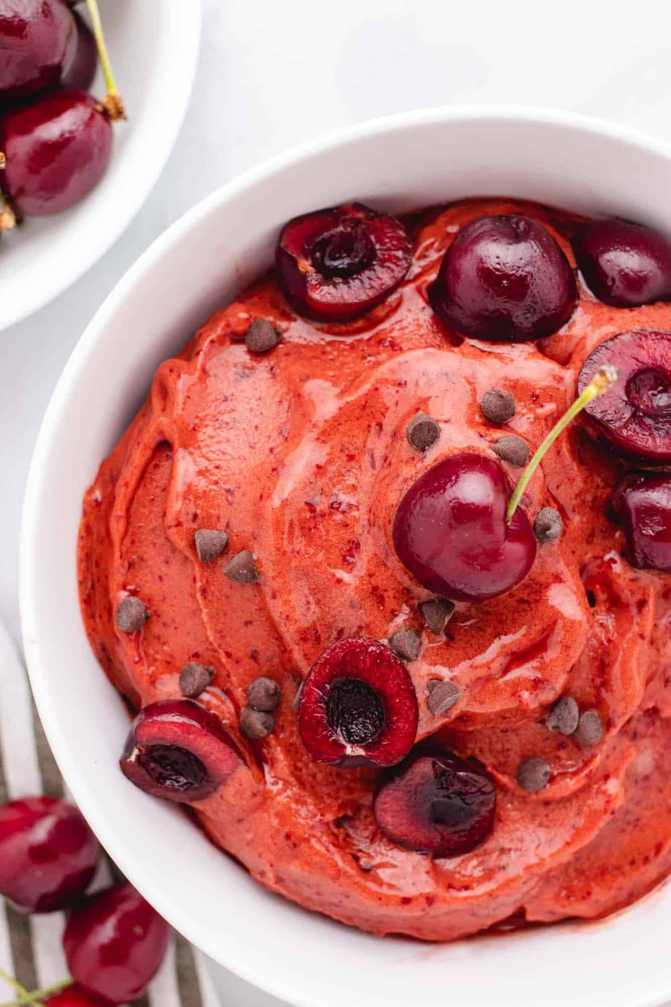 Cherry nice cream in a bowl with sliced cherries.