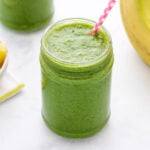 Spinach pineapple banana smoothie in a glass jar.