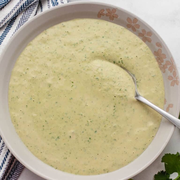 Lemon herb tahini dressing in a bowl with a spoon.