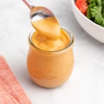 Vegan chipotle sauce in a glass jar with a spoon.
