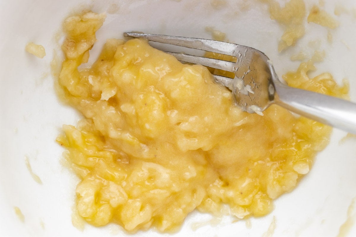 Mashed banana in a bowl with a fork.