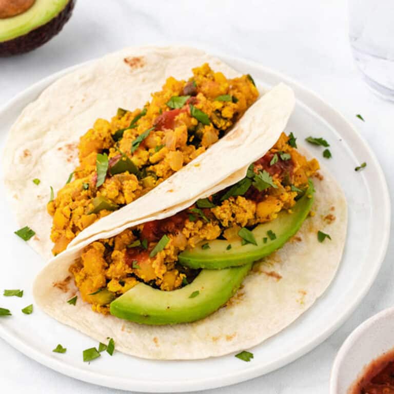 Tofu scramble in tortillas with sliced avocado.