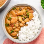Creamy butter bean curry in a bowl with white rice.