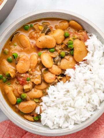 Creamy butter bean curry in a bowl with white rice.