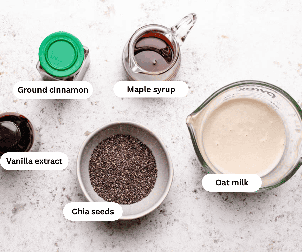 A bottle of ground cinnamon, maple syrup, oat milk, whole flax seeds, and a bottle of vanilla extract.