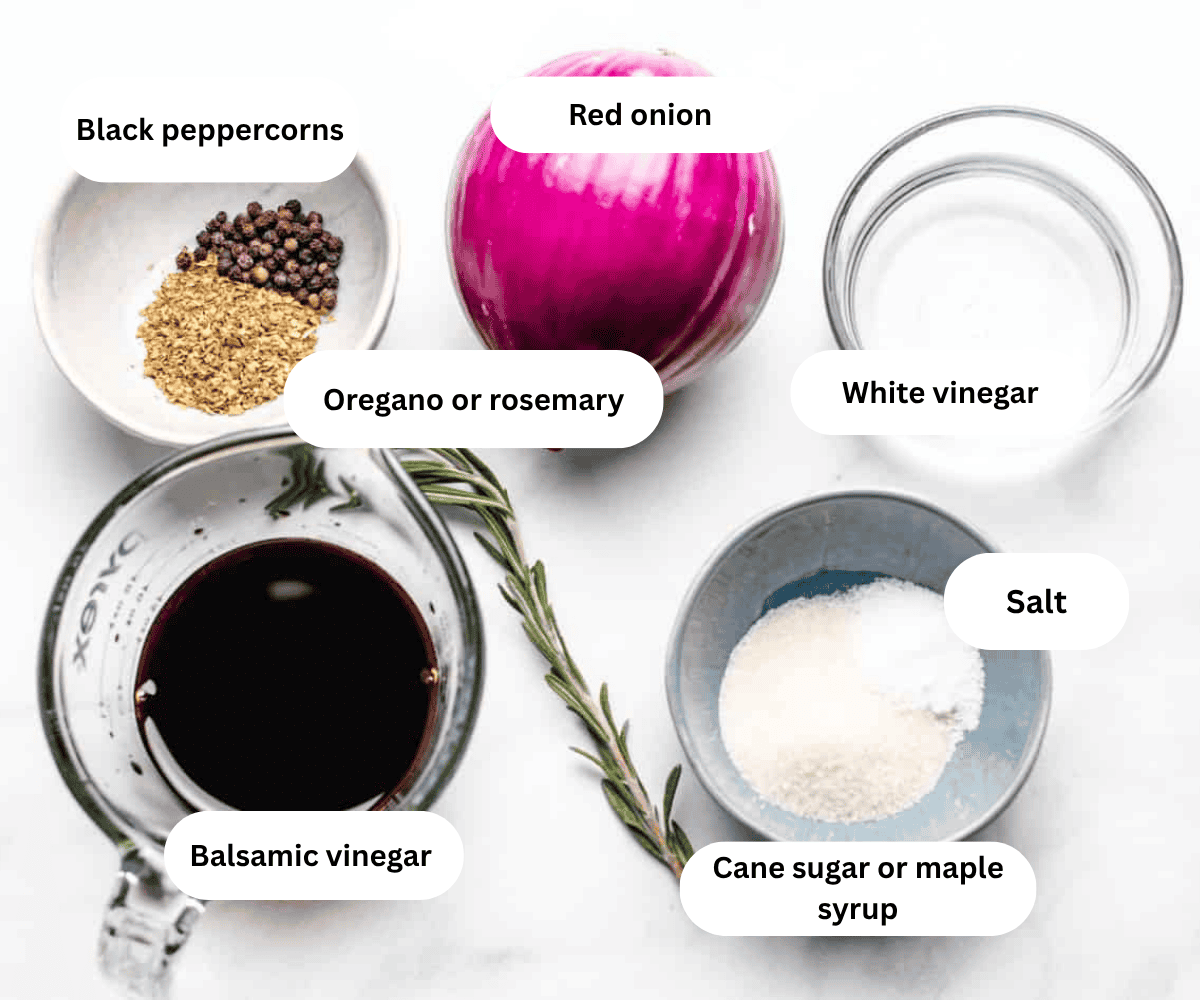 A bowl of dried oregano and black peppercorns, a red onion, a bowl of white vinegar, a bowl of balsamic vinegar, a sprig of rosemary, and a bowl of sugar.