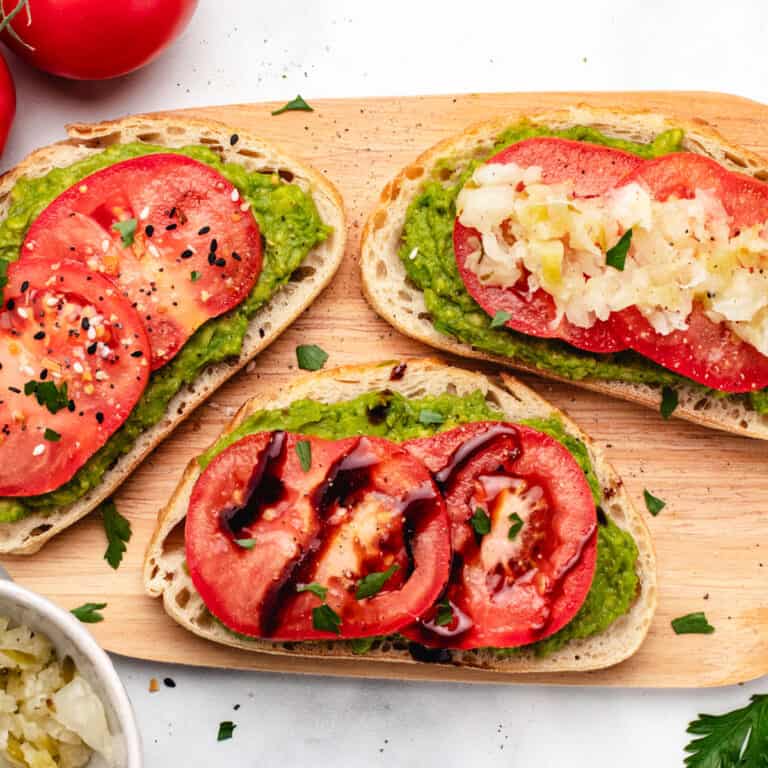 Tomato avocado toast on a cutting board.