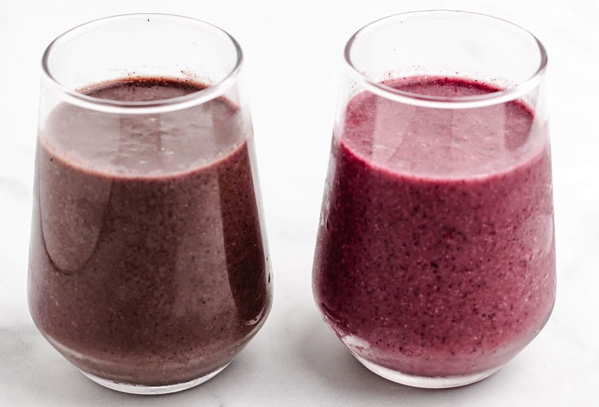 Two smoothies in a glass showing two different colors.