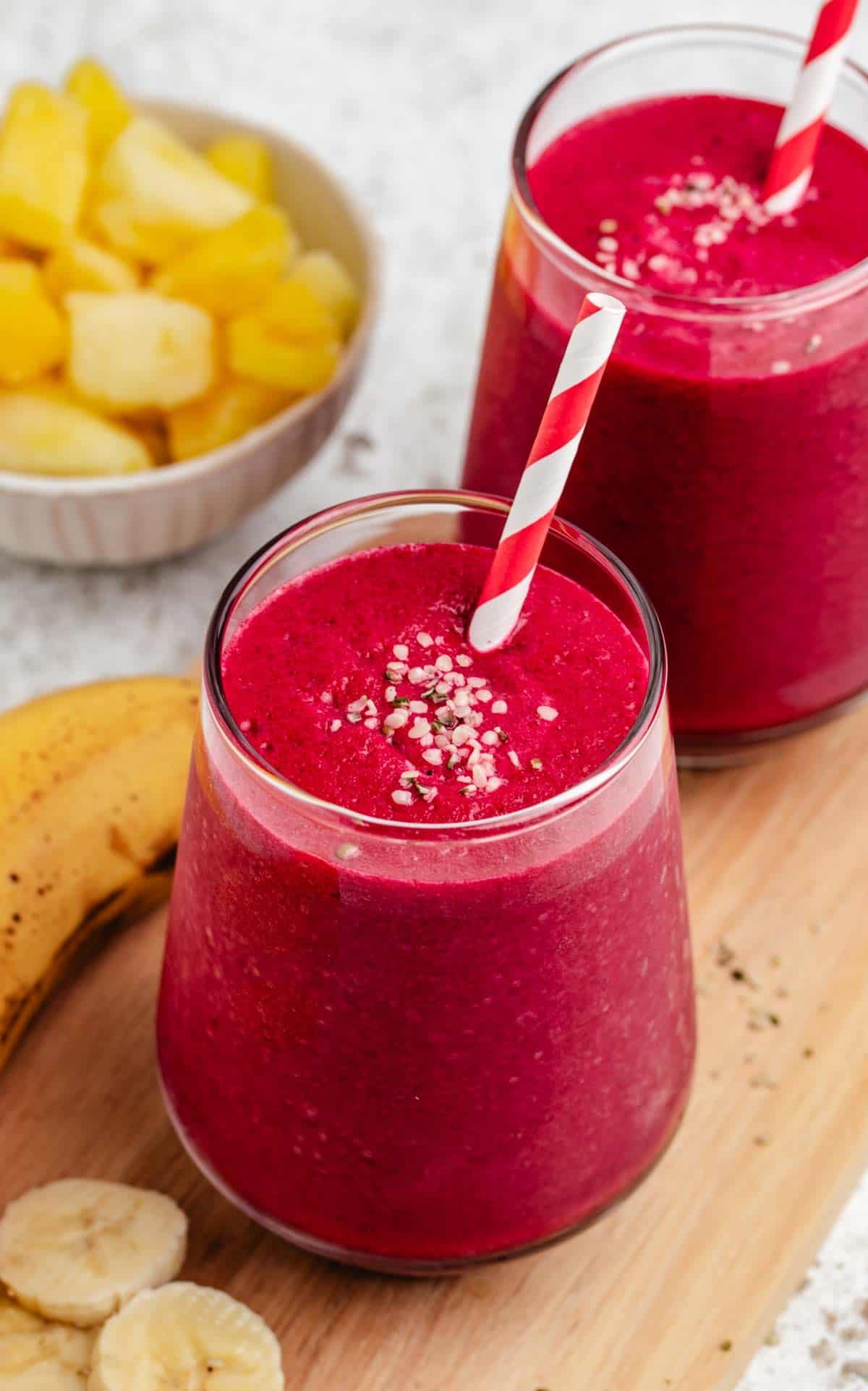 Beet banana smoothie in a glass with a straw.