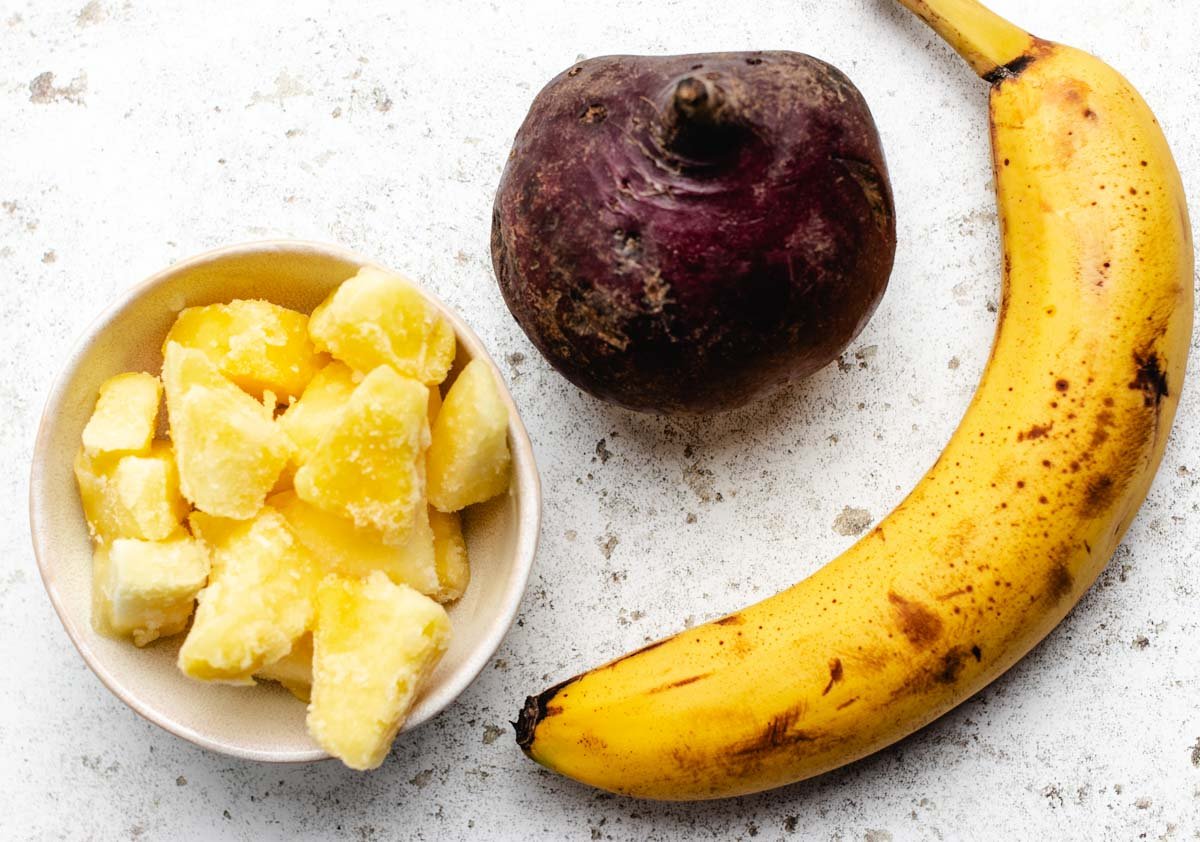 A beet, banana, and a bowl of frozen pineapple.