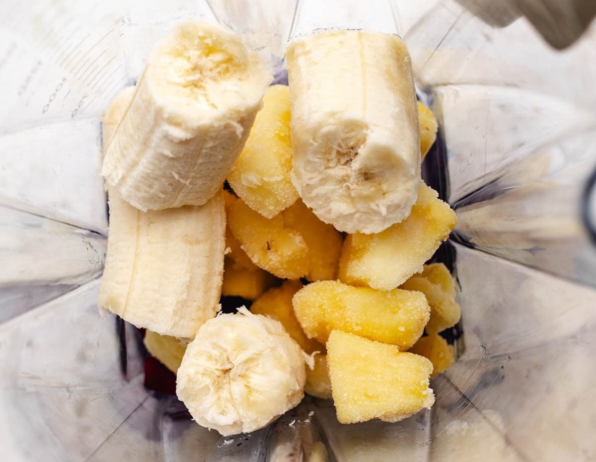 Sliced beet, frozen pineapple, and ripe banana in a blender.