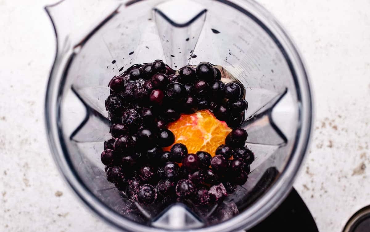 Beets, banana, an orange, and blueberries in a blender.