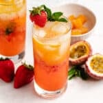 Passion fruit mocktail in a glass with a fresh strawberry and mint leaves.