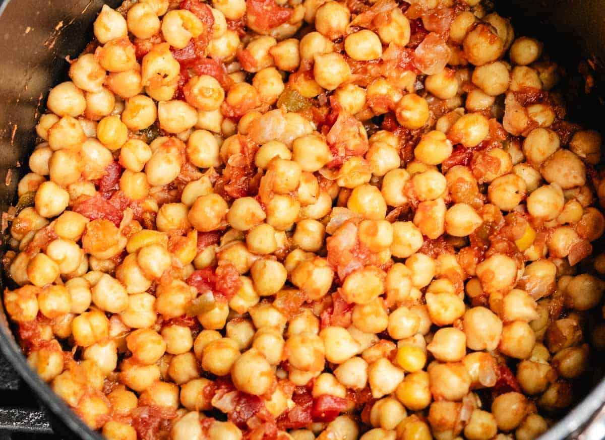 Simmered chickpeas with salsa in a saucepan.