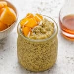 Mango chia pudding with yogurt in a glass with diced mango on top.