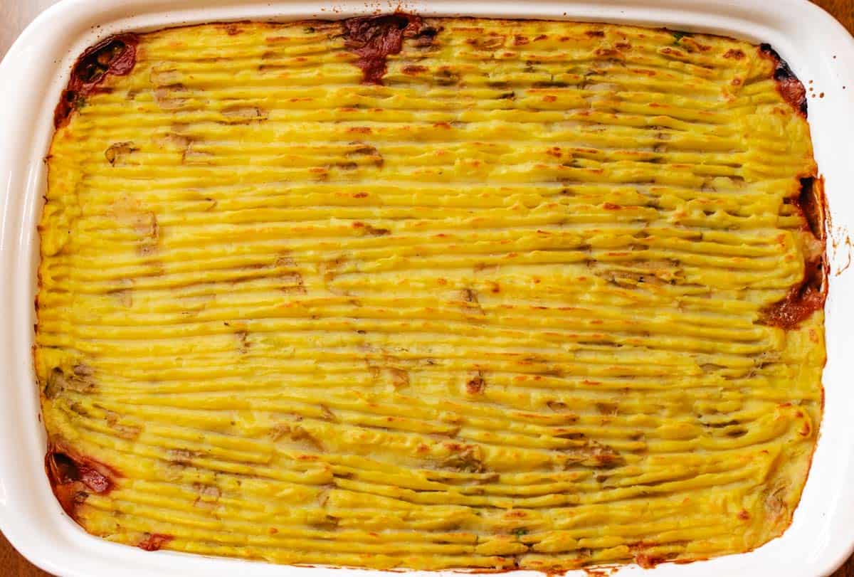 Baked lentil mushroom shepherd's pie in a baking dish with browned mashed potatoes on top.