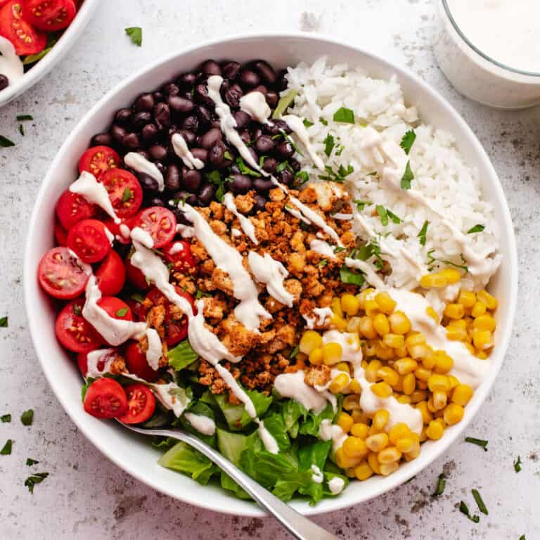 Tofu burrito bowl with black beans, corn, cherry tomatoes, romaine lettuce, and cashew lime crema.