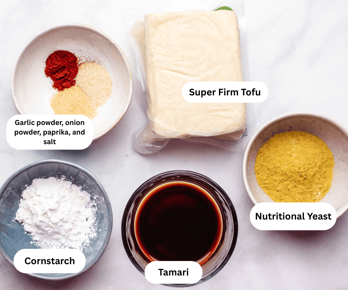 A bowl of spices, super firm tofu, cornstarch, tamari, and nutritional yeast.