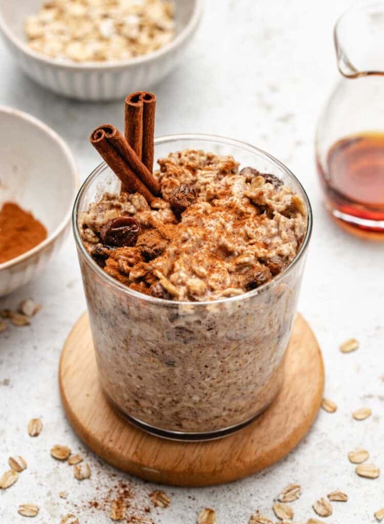 Cinnamon overnight oatmeal in a glass jar with cinnamon on top.