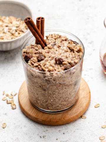 Overnight cinnamon oats in a glass jar with cinnamon sticks.