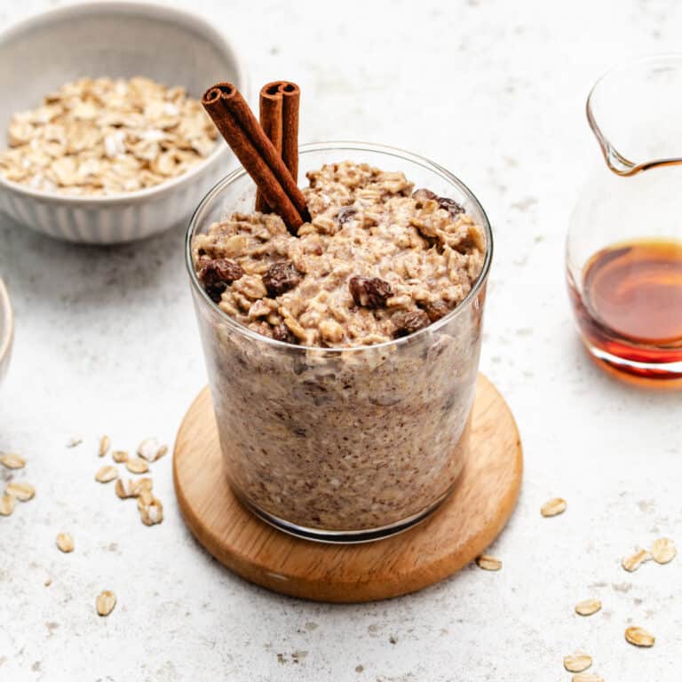 Overnight cinnamon oats in a glass jar with cinnamon sticks.