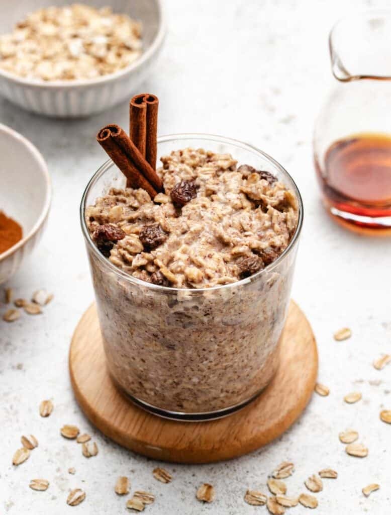 Cinnamon overnight oats in a glass jar with cinnamon sticks.