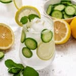 Lemon mint cucumber water in a glass with a lemon slice and a mint sprig.