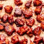 Baked BBQ tofu on a baking tray with parchment paper.