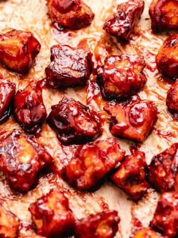Baked BBQ tofu on a baking tray with parchment paper.
